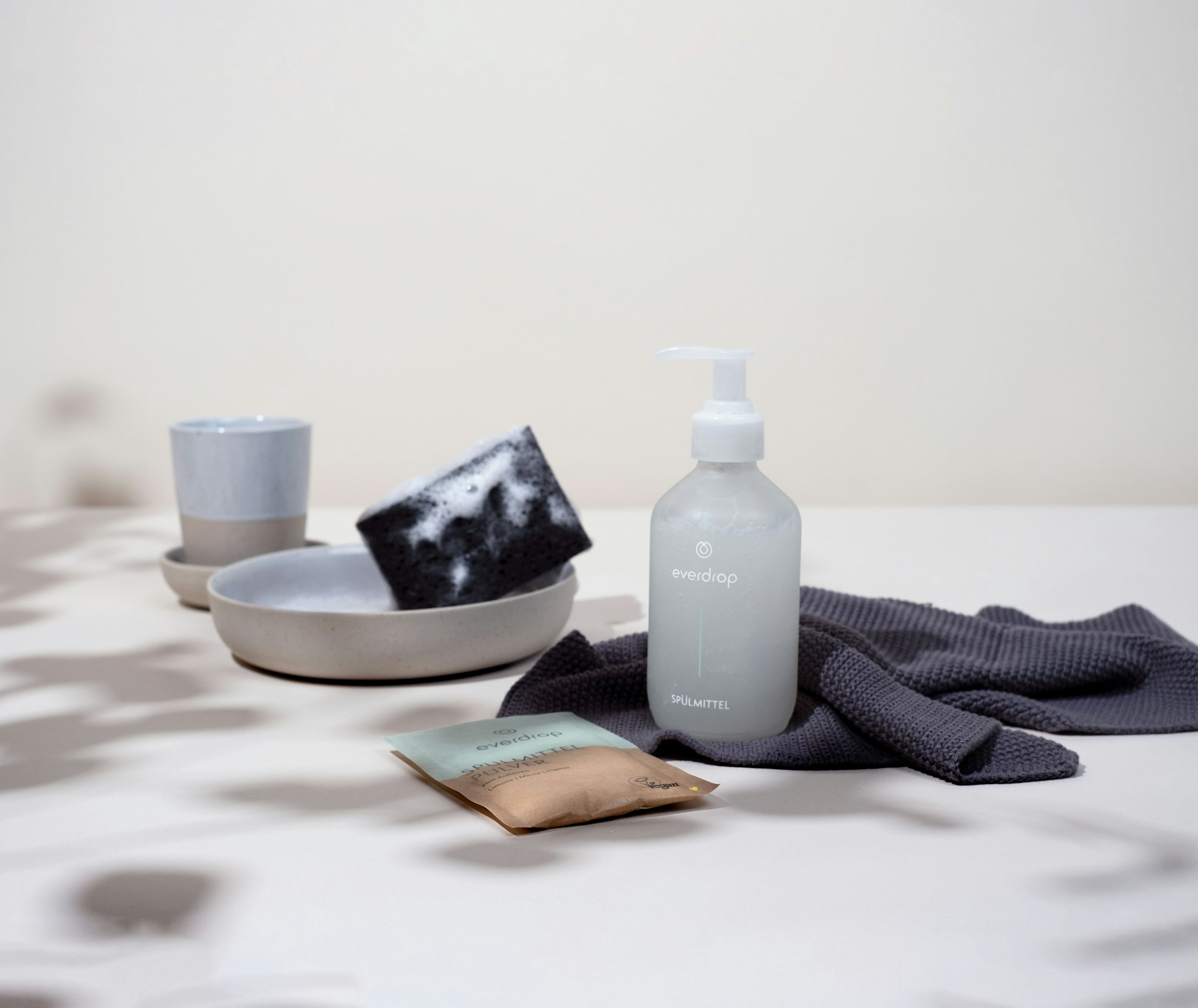 a white table topped with a bottle of lotion and a dish